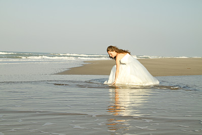 新娘坐在海滩上