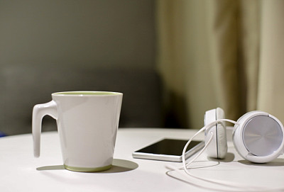 杯子，耳机和智能手机放在桌子上