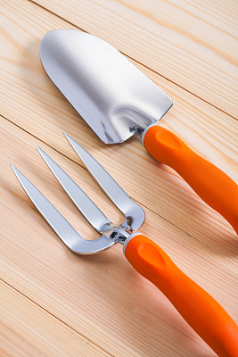 园艺手工工具。木板上的铲子和叉子
