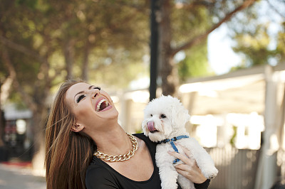 年轻微笑迷人的女人与马耳他贵宾犬