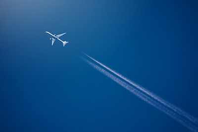 客机在高空，白色的冷凝痕迹