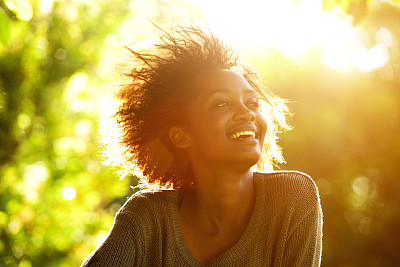 美丽的非洲裔美国妇女与夕阳微笑