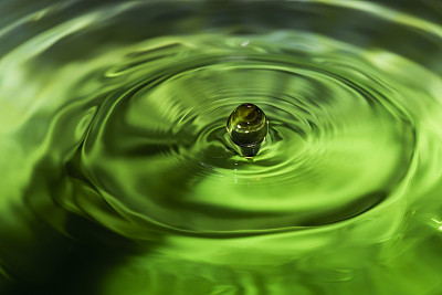 水滴落在绿色的水中，荡起涟漪
