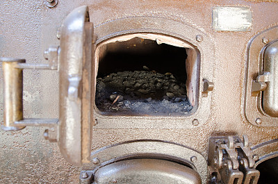靠近煤生锈的炉子，门开着