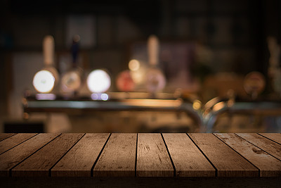 木制的桌子与一个模糊的饮料酒吧背景
