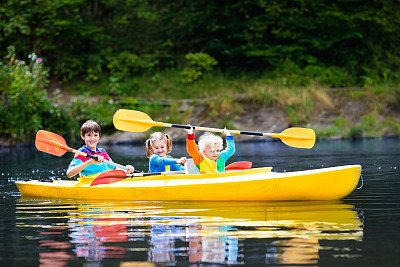 炎炎夏日，孩子们在河上划皮艇