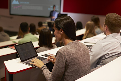 成人学生在大学讲座上使用笔记本电脑