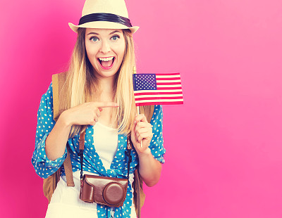 快乐的年轻女旅行者举着美国国旗
