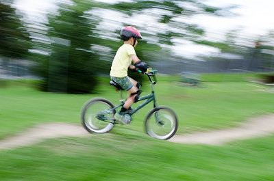 小男孩在土路上骑自行车