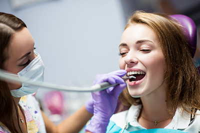 牙科医生在牙科诊所给一位女病人治病