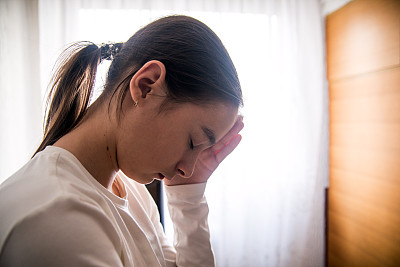 悲伤的少女在她的客厅里沉思