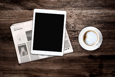 每天的报纸，咖啡和黑屏平板电脑。