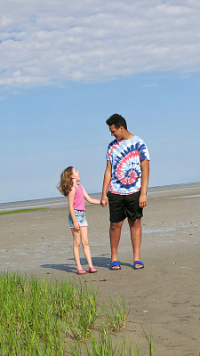 少年男孩和孩子手牵手在海滩上