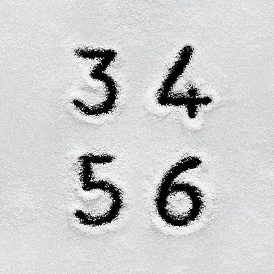 冬天的字母、符号和数字手写在雪地上。
