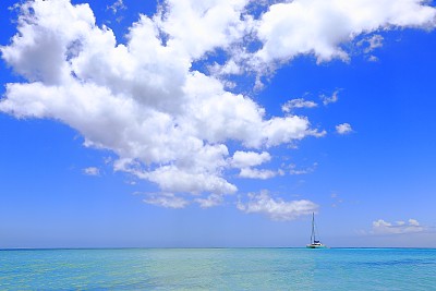 热带天堂:绿松石加勒比海，游艇在戏剧性的天空下航行