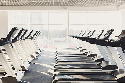 现代化的健身房内部配备设备，跑步机健身有氧训练