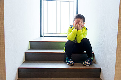孤独的孩子坐在楼梯上