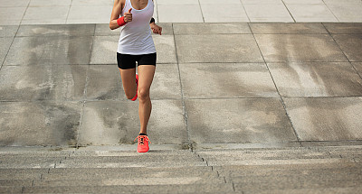 年轻的女运动员在城市的楼梯上奔跑