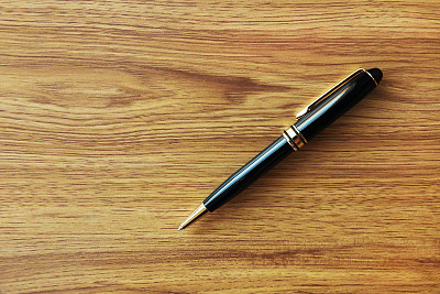 一只黑色的商业笔在木头背景上