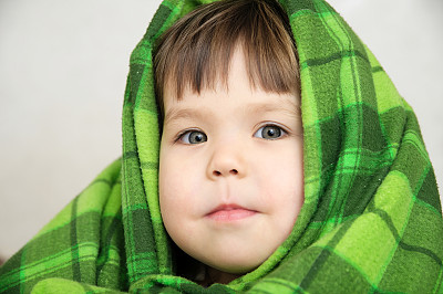 孩子肖像在毯子微笑表达情感，温暖的毯子舒适