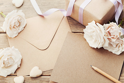信封或信件，礼物，纸卡和玫瑰。问候的概念。