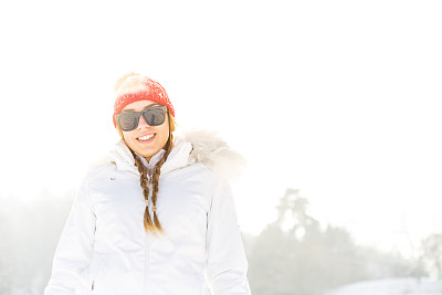 在雪地里戴着太阳镜和帽子的女人