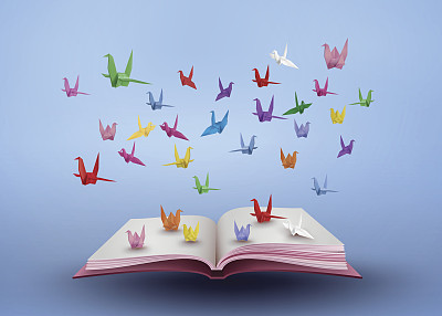 折纸使五彩的纸鸟飞过打开的书