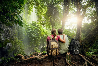 一对背包徒步者在热带雨林欣赏瀑布