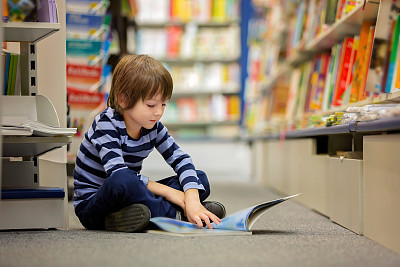 可爱的小男孩，坐在书店里看书