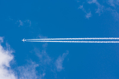 白云蓝天蓬松的太阳耀斑飞机踪迹晴朗的白天纹理背景
