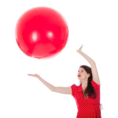 一个女人在她头上抓住一个红色的大气球