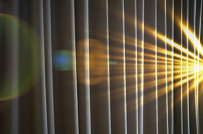 强烈的光线照射在窗帘上，伴有镜头光晕