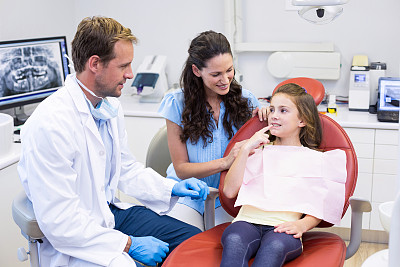 年轻病人向牙医展示牙齿