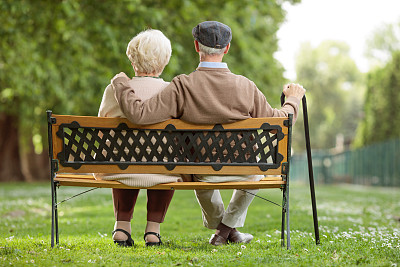 一对老年夫妇坐在公园的木凳上