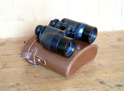 老式棱镜黑色双筒望远镜和棕色皮箱
