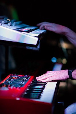 音乐家在双键盘合成器钢琴键上演奏。音乐家在音乐会舞台上演奏乐器