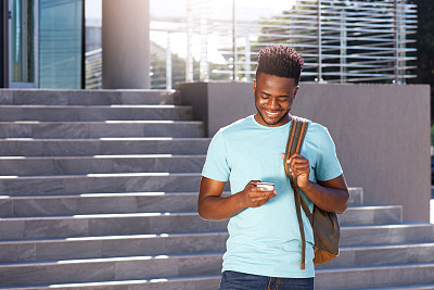 微笑的非洲裔美国学生看着手机
