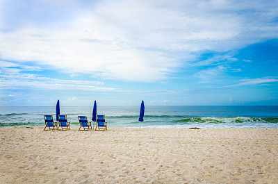 热带白色沙滩景色与沙滩椅和雨伞