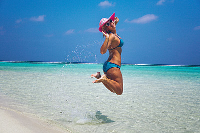 在马尔代夫海滩上跳的女人