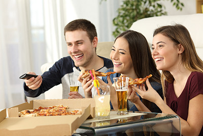朋友们看电视，吃披萨