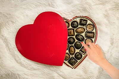 一位女士伸手去拿巧克力糖