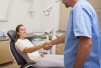 牙医和坐在椅子上的病人握手