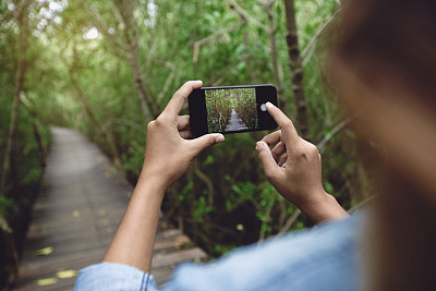 女人用手机拍自然照片