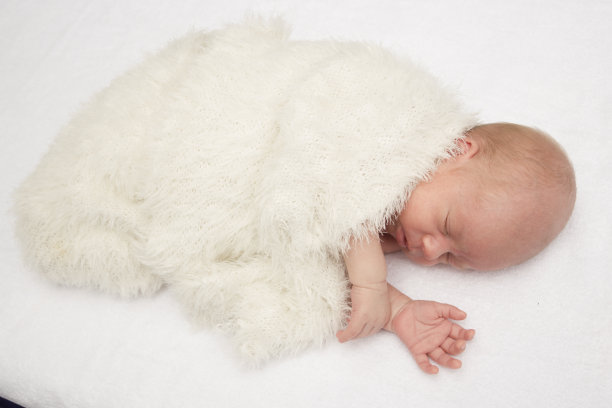 新生儿躺在白色毯子里的特写镜头