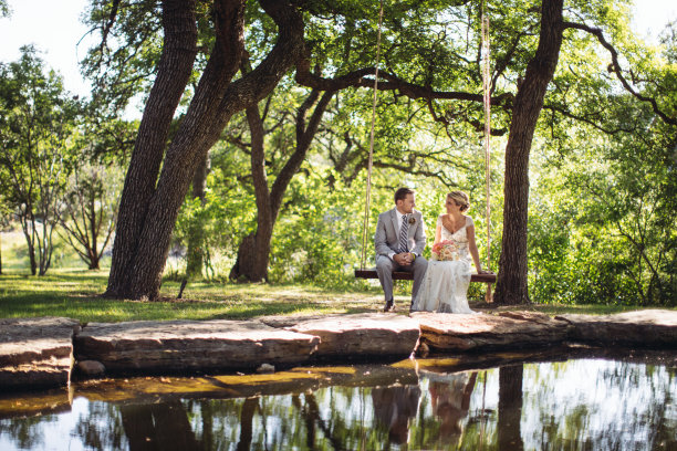 微笑的年轻夫妇坐在池边