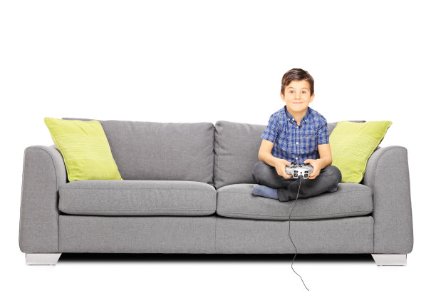 在沙发上玩游戏的男孩的肖像
