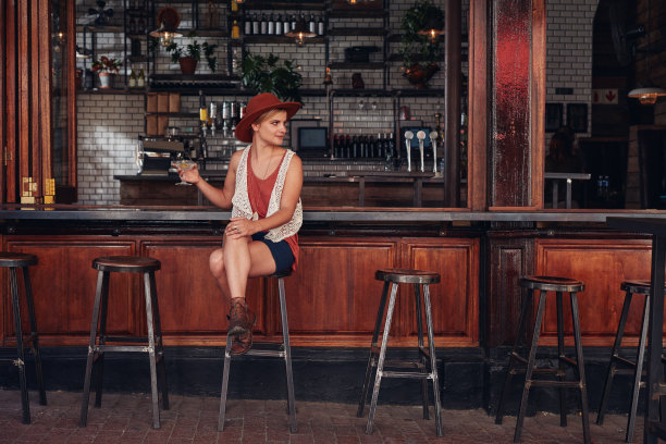 坐在吧台上喝酒的年轻女性