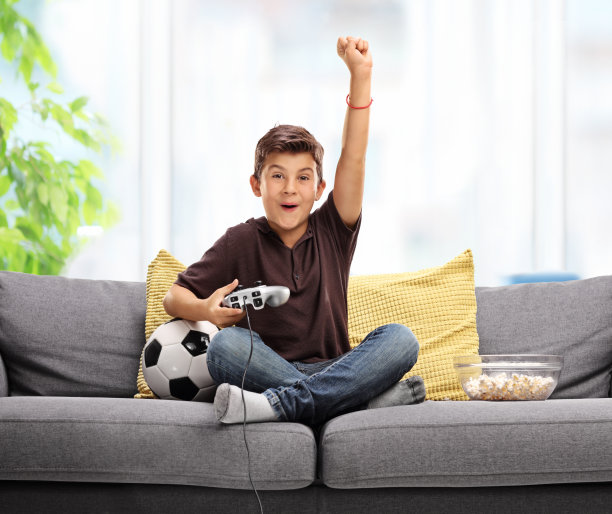 在沙发上玩游戏的男孩的肖像