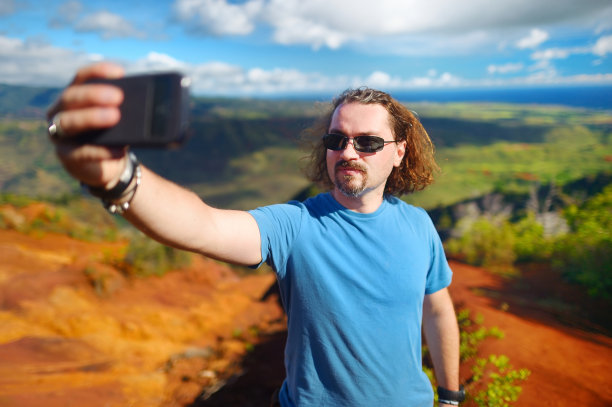 手持手机拍摄山间风景