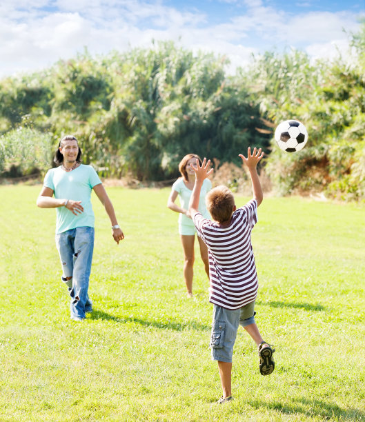 在公园里踢足球的家人